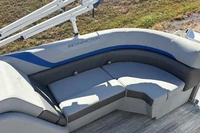 Slide: The Image of 2025 Bennington 22SXSR boat seating with gray and blue upholstery, outdoor setting. - 9