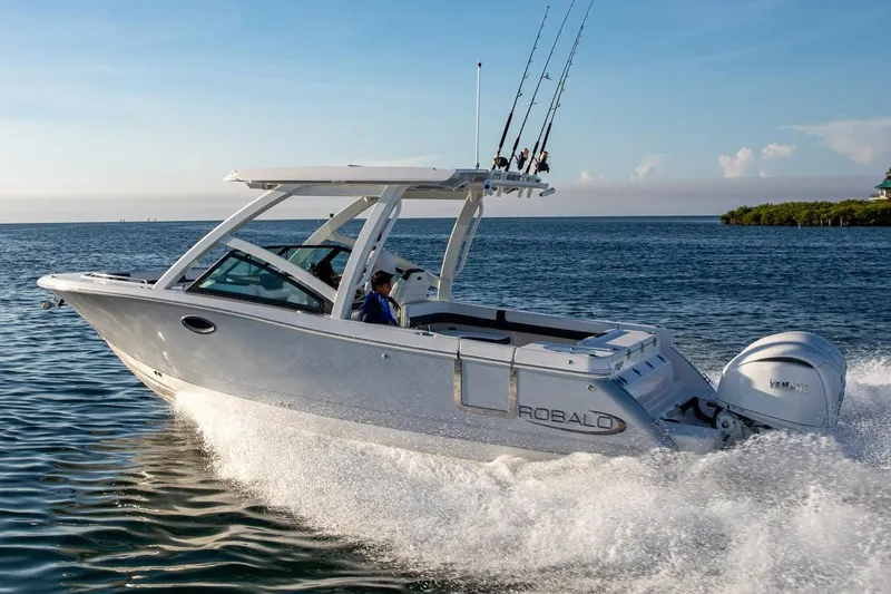 Slide: The Image of Manufacturer Provided Image: 2026 Robalo R277 Dual Console boat cruising on open water, featuring sleek design and powerful engine. - 2