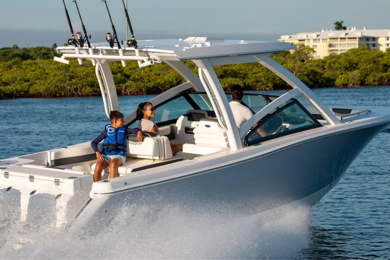 Slide: The Image of Manufacturer Provided Image: 2026 Robalo R277 Dual Console boat cruising with passengers on a sunny day. - 3