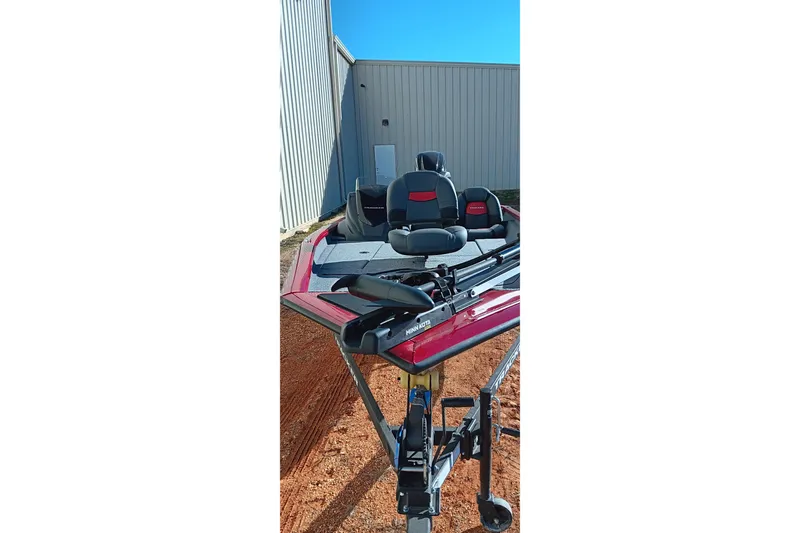 Slide: The Image of 2025 Tracker Pro Team 175 boat with seating, parked outdoors near a building. - 10