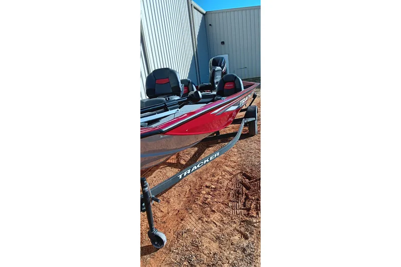 Slide: The Image of 2025 Tracker Pro Team 175 boat on trailer, red exterior, parked outdoors. - 11