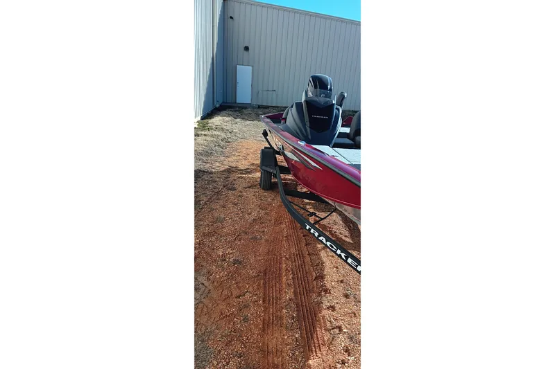 Slide: The Image of 2025 Tracker Pro Team 175 boat on trailer near building. - 12