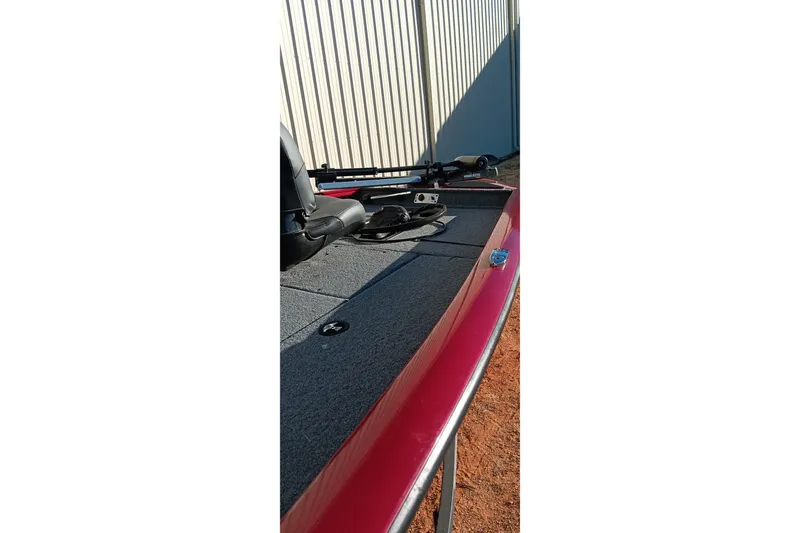 Slide: The Image of 2025 Tracker Pro Team 175 boat deck with red trim and fishing equipment. - 4
