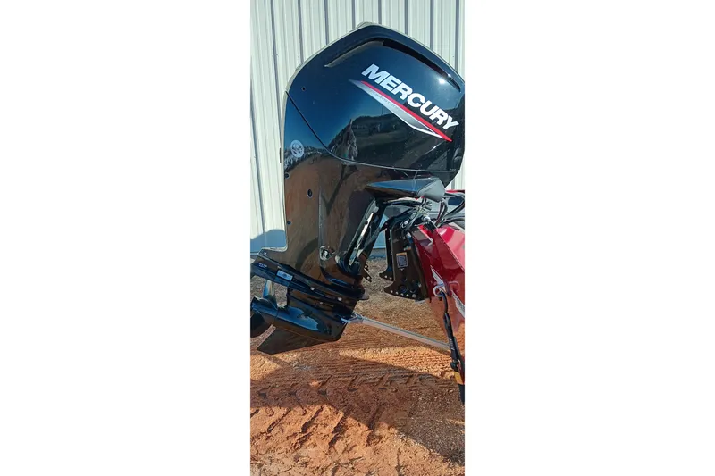 Slide: The Image of 2025 Tracker Pro Team 175 with Mercury outboard motor, parked on sandy ground. - 9