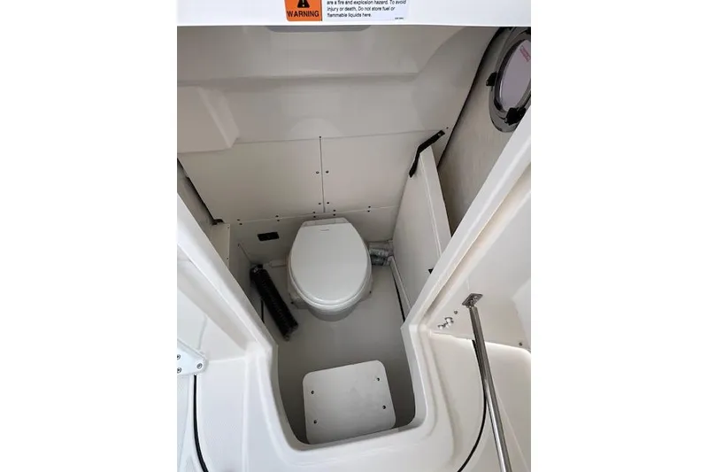 Slide: The Image of 2026 Robalo R270 Center Console boat interior with compact marine toilet. - 26