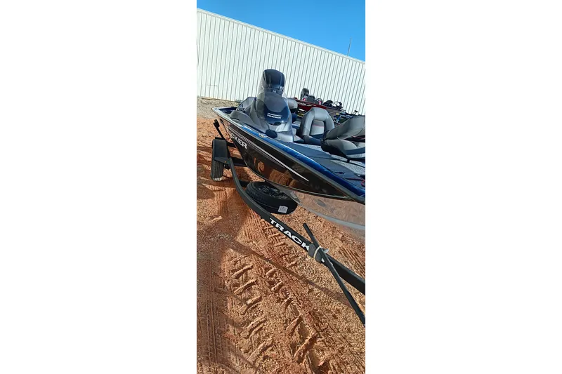 Slide: The Image of 2024 Tracker Pro Team 175 TXW boat on trailer, parked on sandy ground. - 10