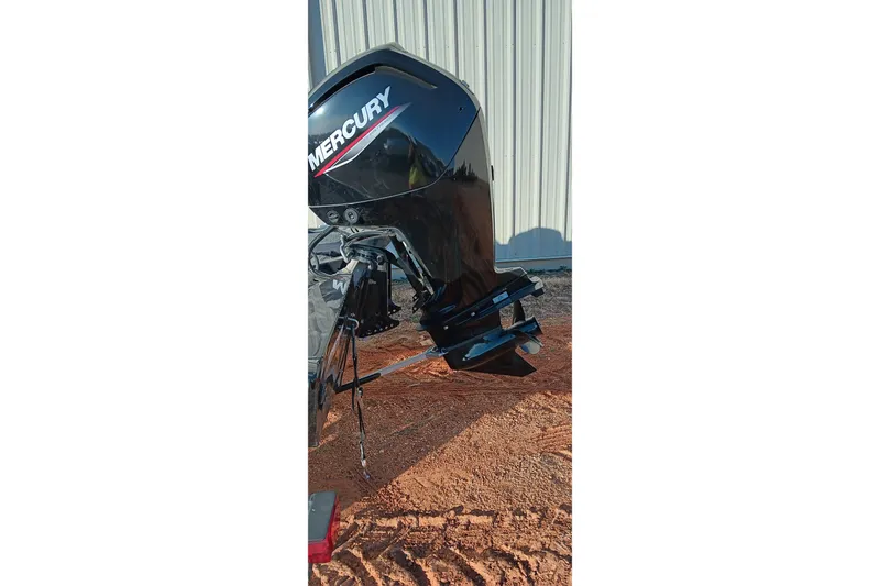 Slide: The Image of 2024 Tracker Pro Team 175 TXW with Mercury outboard motor, parked on sandy ground. - 14