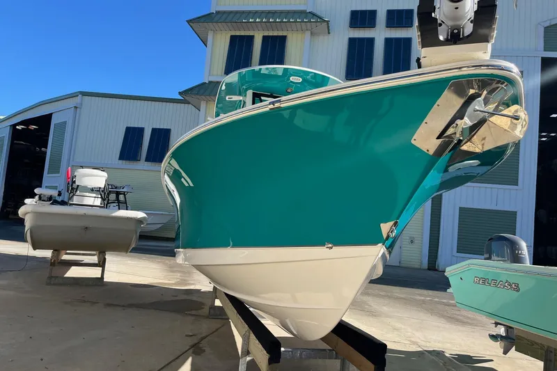 The Image of 2021 Sea Hunt Gamefish 27 Coffin Box boat in marina, vibrant teal hull. - 0
