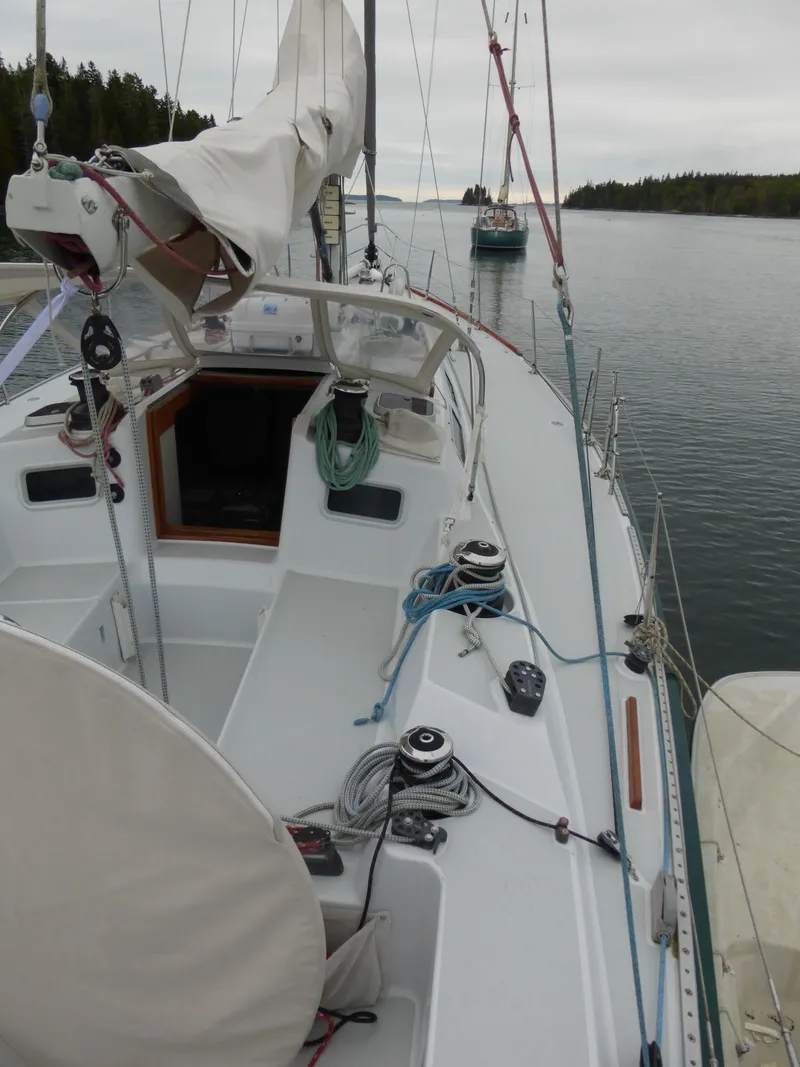 Slide: The Image of 1989 J Boats J/44 sailboat docked on calm water, featuring a clean deck and rigging. - 10