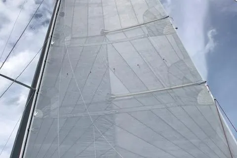 Slide: The Image of Sail of a 1989 J Boats J/44 against a cloudy sky. - 12