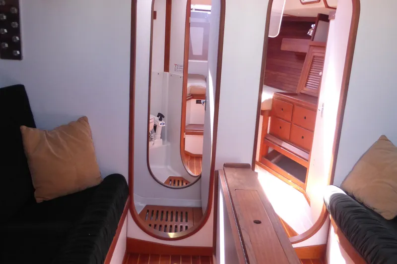 Slide: The Image of Interior of 1989 J Boats J/44 yacht, featuring wood accents and cozy seating. - 28