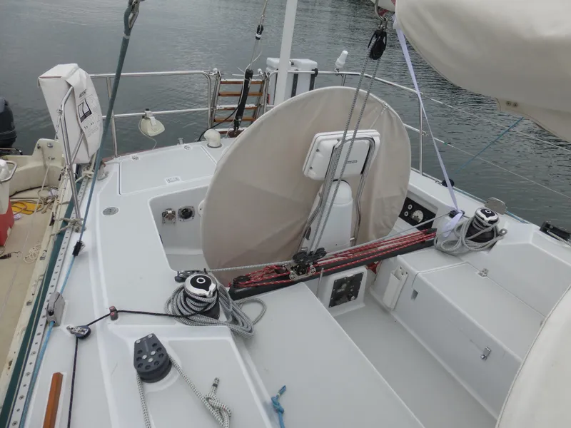 Slide: The Image of 1989 J Boats J/44 sailboat cockpit with ropes and winches, docked on calm water. - 8