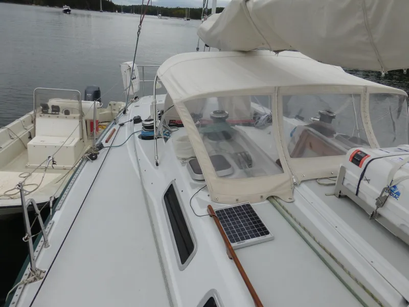 Slide: The Image of 1989 J Boats J/44 sailboat with canopy and solar panel, docked on calm water. - 9