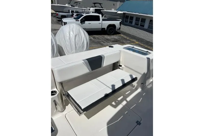 Slide: The Image of 2026 Robalo R300 Center Console boat with foldable seating in a marina setting. - 17