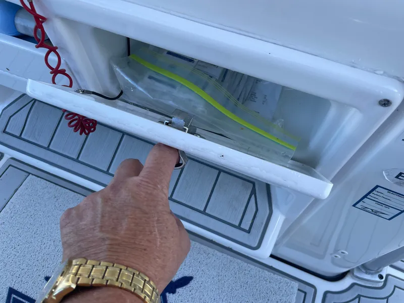 Slide: The Image of Hand opening compartment on a 2017 Tidewater 220 boat. - 28