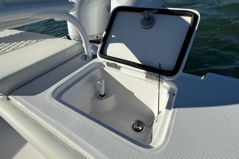 Slide: The Image of Open storage compartment on 2026 Jupiter 26 boat, featuring sleek white design. - 21
