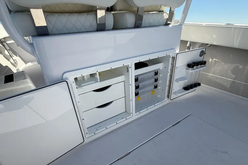 Slide: The Image of Interior storage compartments of a 2026 Jupiter 26 boat, featuring organized drawers and holders. - 22