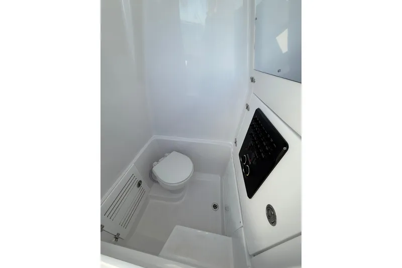 Slide: The Image of Compact bathroom in 2026 Jupiter 26 model boat, featuring a toilet and control panel. - 24