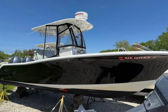 Slide: The Image of 2013 NauticStar 2500XS Offshore boat on display, black hull, clear sky background. - 4