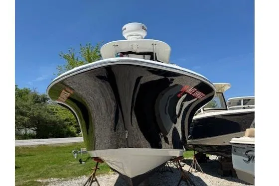 Slide: The Image of 2013 NauticStar 2500XS Offshore boat on display, black hull, parked outdoors. - 5