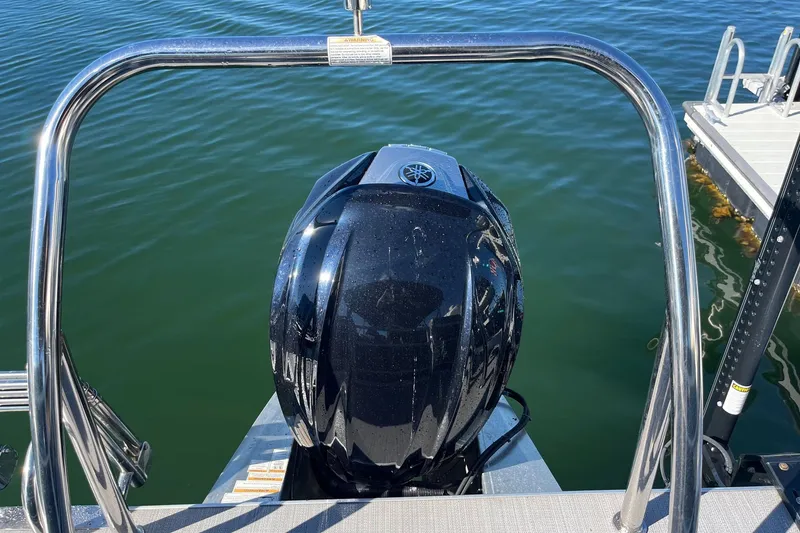 Slide: The Image of 2023 Veranda Relax VR22RC pontoon boat docked on calm water. - 10