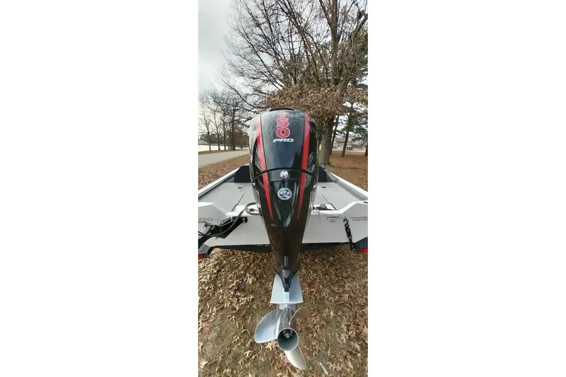 Slide: The Image of 2022 Tracker Pro Team 195 TXW boat with powerful outboard motor in a wooded area. - 10