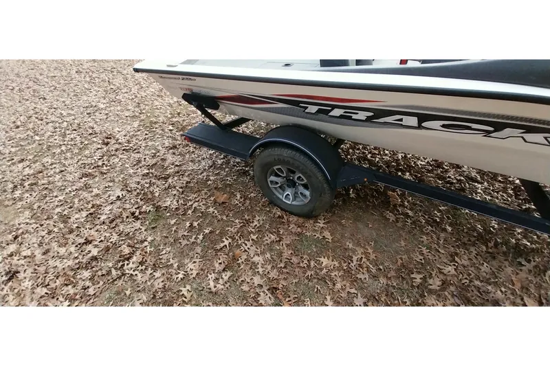 Slide: The Image of 2022 Tracker Pro Team 195 TXW boat on trailer, surrounded by autumn leaves. - 15