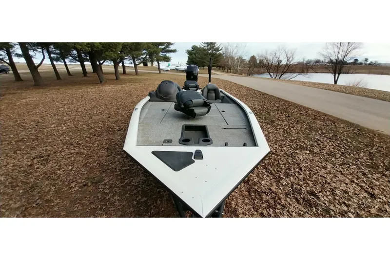 Slide: The Image of 2022 Tracker Pro Team 195 TXW boat on a leaf-covered ground near a lake. - 30