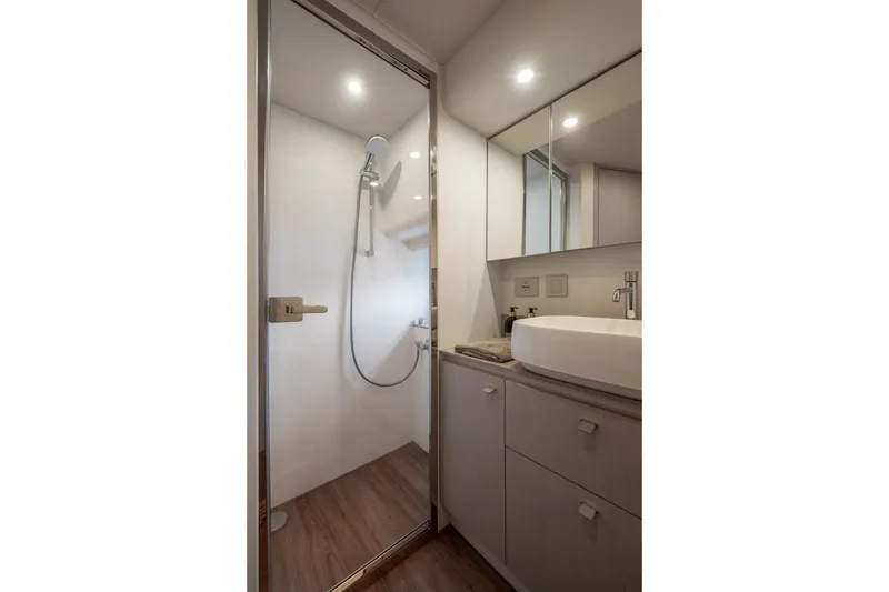 Slide: The Image of The image shows a modern bathroom on a boat with a shower enclosure and a sink. - 36