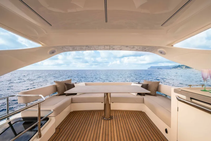 Slide: The Image of Absolute 50 Navetta 2027: Elegant aft deck with seating area, table, and ocean view. - 16