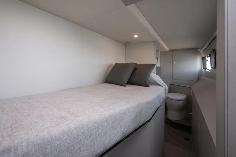 Slide: The Image of The Absolute 50 Navetta 2027 cabin features a bed with gray bedding and pillows. - 38