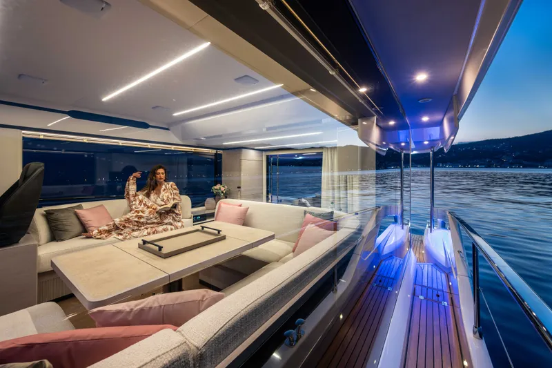 Slide: The Image of An elegant yacht with a stylish interior and exterior deck, lit at sunset on calm waters. - 30