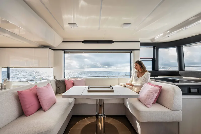 Slide: The Image of A woman sits in an elegant salon with white and pink cushions, gazing out at the sea. - 25