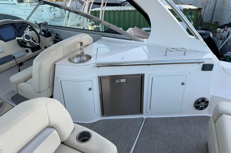 Slide: The Image of 2019 Regal 33 OBX boat interior with helm, sink, and seating area. - 19