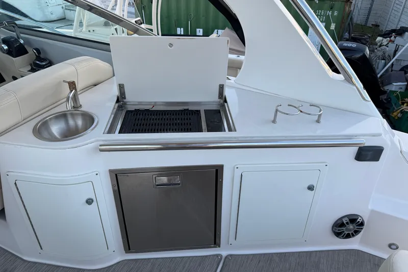 Slide: The Image of 2019 Regal 33 OBX boat kitchenette with sink, grill, and storage cabinets. - 20