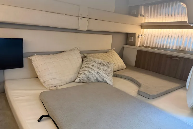 Slide: The Image of 2019 Regal 33 OBX cabin interior with cozy bedding and ambient lighting. - 26