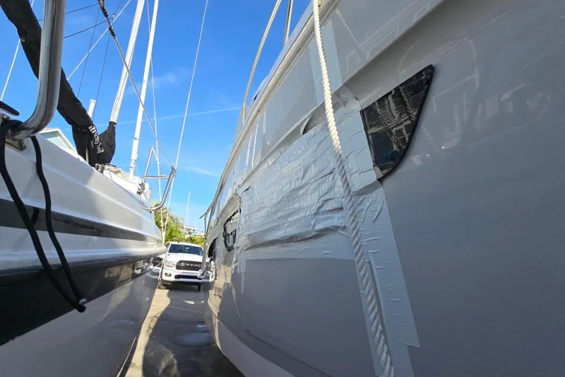Slide: The Image of 2019 Regal 33 OBX boat with taped hull, docked beside another vessel. - 3