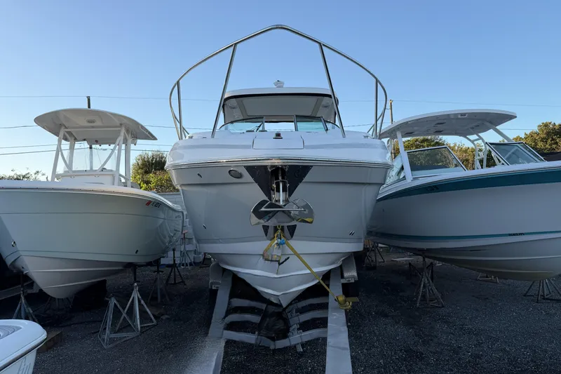 Slide: The Image of 2019 Regal 33 OBX boat on stands, flanked by two other boats, in a storage yard. - 39
