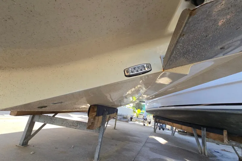 Slide: The Image of 2019 Regal 33 OBX boat hull on stands, underside view. - 5