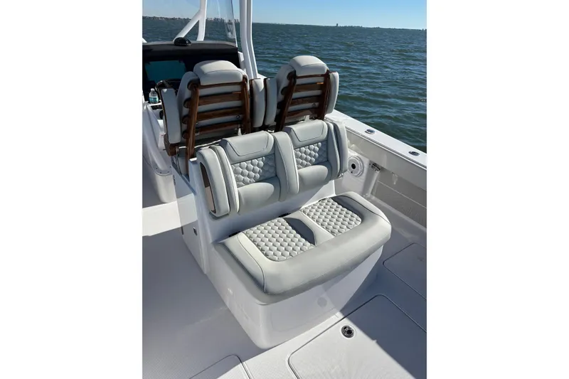 Slide: The Image of Luxury seating on 2026 Jupiter 32 boat, featuring quilted upholstery and ocean backdrop. - 25