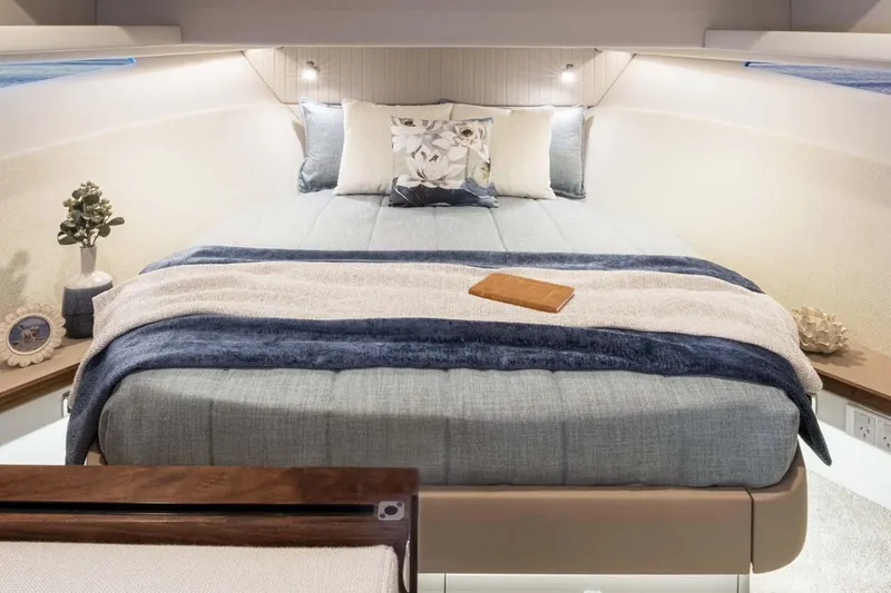 Slide: The Image of Manufacturer Provided Image: Luxurious bedroom interior of 2026 Riviera 4300 Sport Express yacht, featuring elegant bedding and decor. - 12