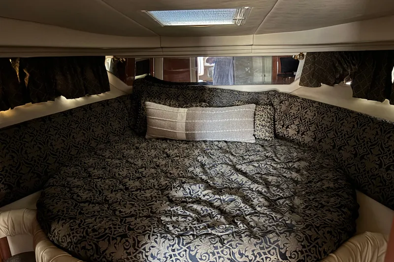Slide: The Image of Luxurious cabin interior of 1999 Sea Ray 380 Sundancer with patterned bedding. - 12
