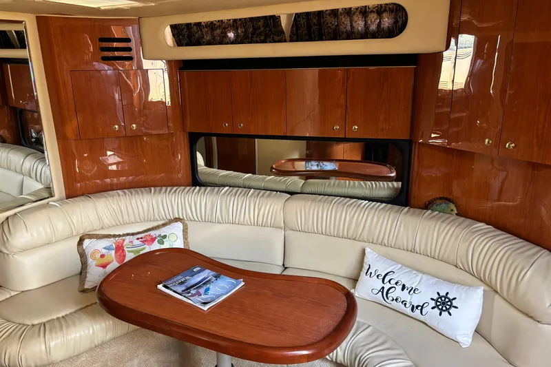Slide: The Image of Luxurious interior of 1999 Sea Ray 380 Sundancer yacht with plush seating and wooden cabinetry. - 8