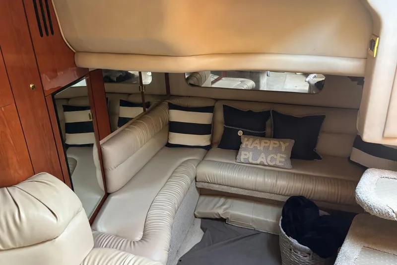 Slide: The Image of Interior of 1999 Sea Ray 380 Sundancer with cozy seating and decorative pillows. - 9