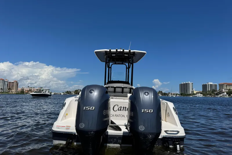 Slide: The Image of 2022 Robalo R242 Center Console boat with dual Yamaha 150 engines on a sunny day. - 1