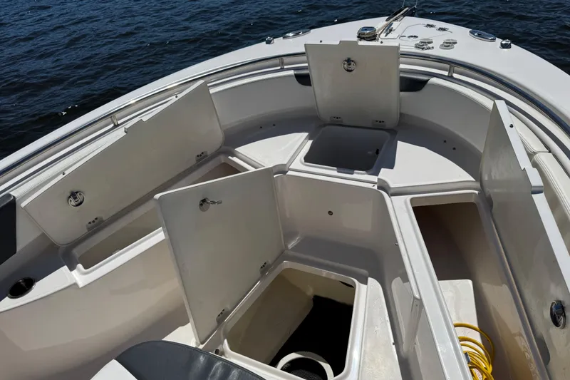 Slide: The Image of 2022 Robalo R242 Center Console boat with open storage compartments on deck. - 10