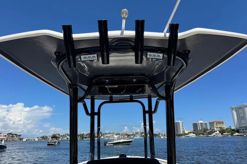 Slide: The Image of 2022 Robalo R242 Center Console boat with T-top, on a sunny waterfront. - 14