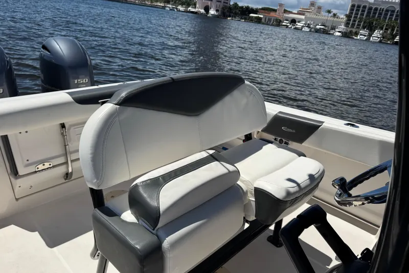 Slide: The Image of 2022 Robalo R242 Center Console boat interior with dual engines on a scenic waterfront. - 16