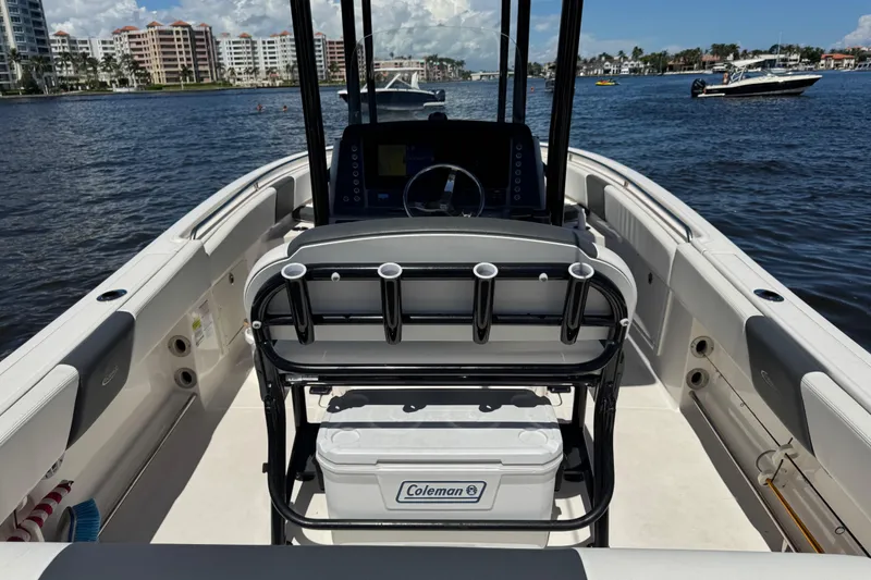 Slide: The Image of 2022 Robalo R242 Center Console boat interior with seating and steering, docked on a sunny day. - 17