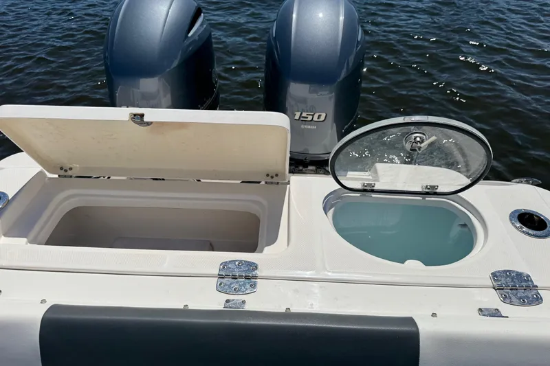 Slide: The Image of 2022 Robalo R242 Center Console boat with open storage compartments and twin Yamaha 150 engines. - 21